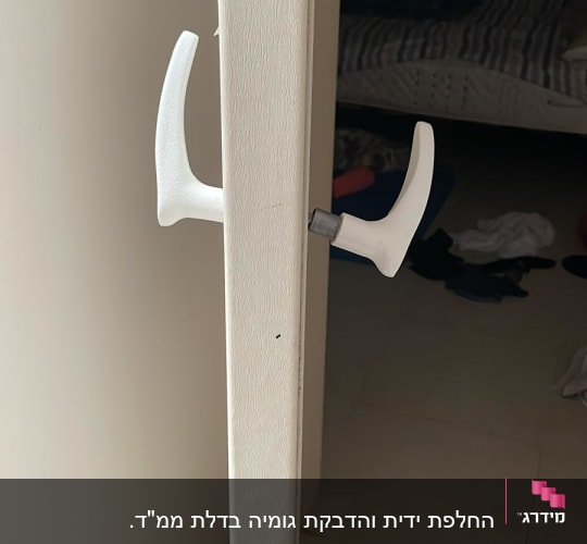 ידית דלת לבנה מותקנת על דלת פתוחה